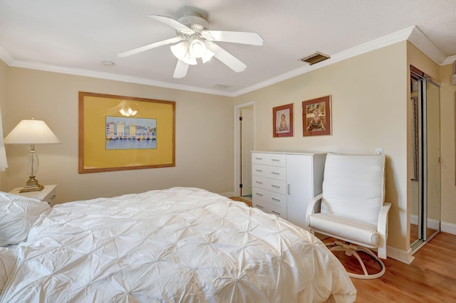 bedroom featuring hardwood / wood-style floors, crown molding, and ceiling fan