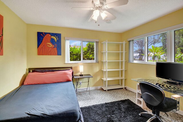 bedroom with ceiling fan and a textured ceiling