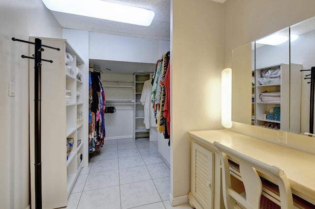 walk in closet with light tile patterned floors