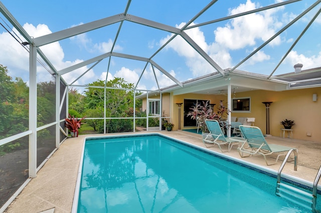 view of swimming pool with a lanai, a patio area, and ceiling fan