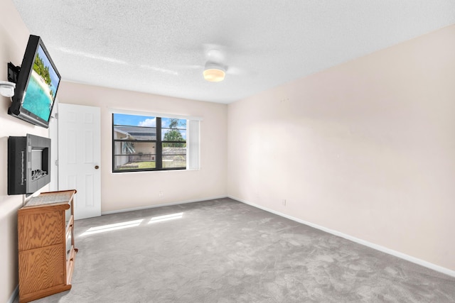 interior space featuring baseboards, carpet floors, and a textured ceiling