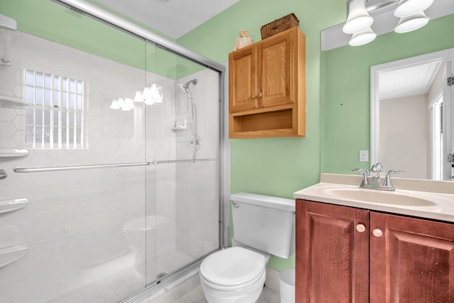 bathroom featuring toilet, a stall shower, and vanity