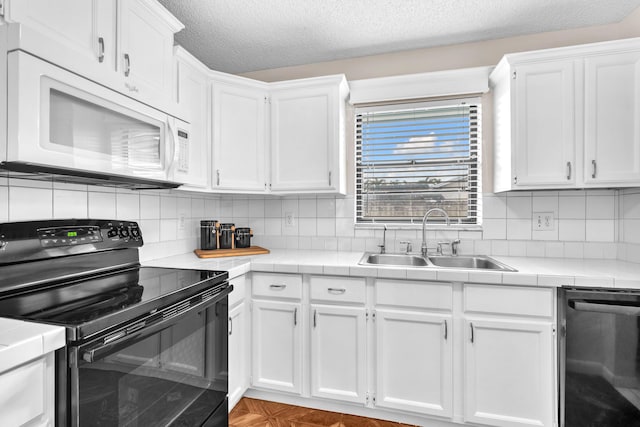 kitchen with white microwave, a sink, black electric range, white cabinets, and stainless steel dishwasher