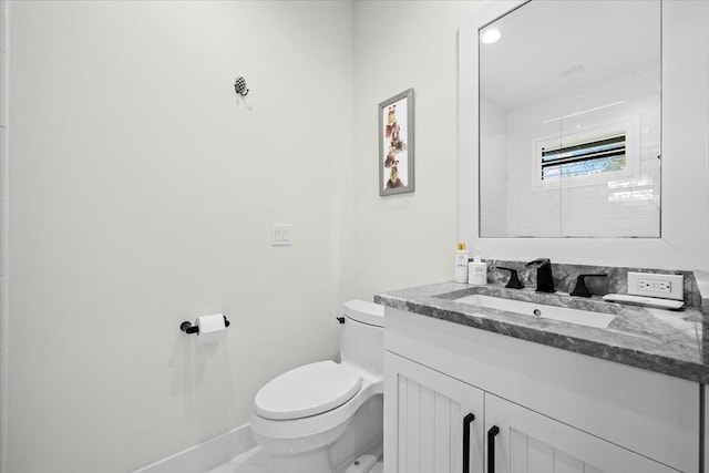 bathroom with toilet, baseboards, and vanity