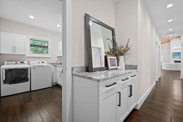 laundry room featuring recessed lighting, dark wood-style flooring, cabinet space, and washing machine and clothes dryer