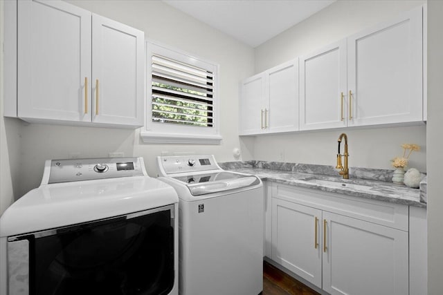 laundry room with separate washer and dryer, a sink, and cabinet space