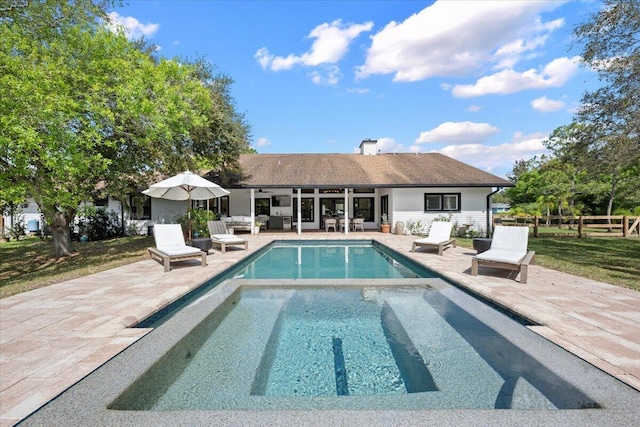 outdoor pool with a patio area and fence