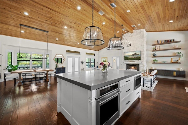 kitchen with a kitchen island, white cabinetry, pendant lighting, and open floor plan