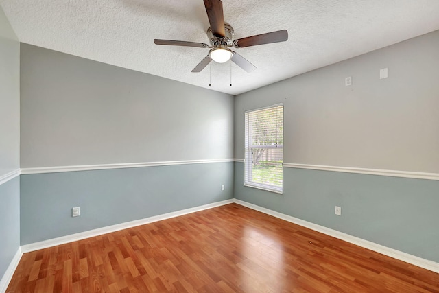 unfurnished room with ceiling fan, wood-type flooring, and a textured ceiling