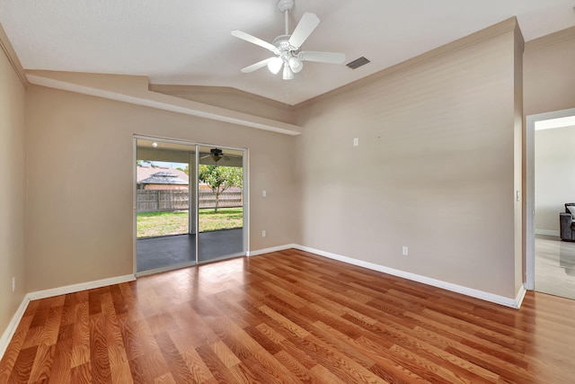 spare room featuring wood-type flooring, ornamental molding, ceiling fan, and vaulted ceiling