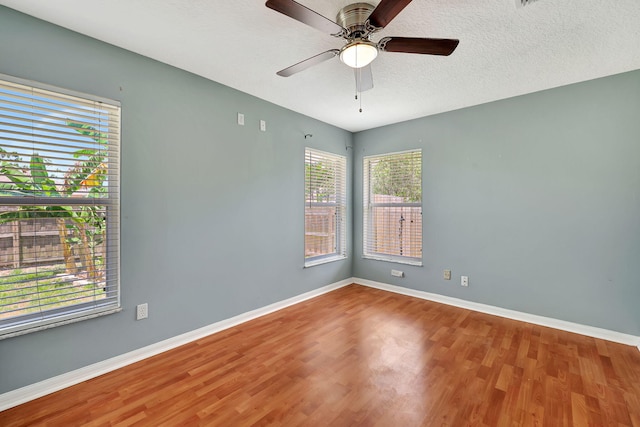 empty room with ceiling fan, hardwood / wood-style flooring, and a textured ceiling