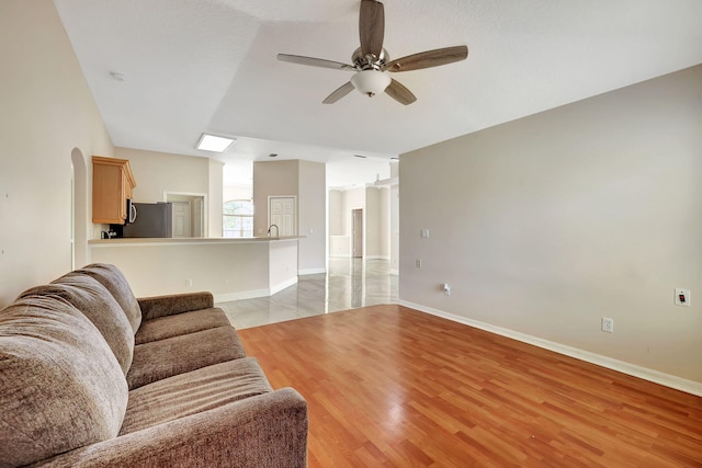 living room with ceiling fan and light hardwood / wood-style flooring