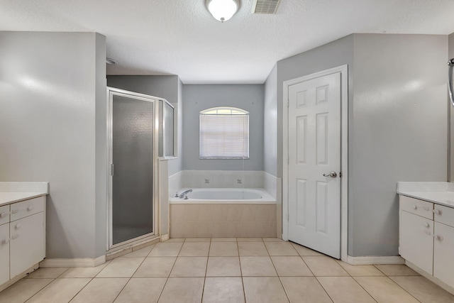 bathroom with vanity, plus walk in shower, tile patterned flooring, and a textured ceiling