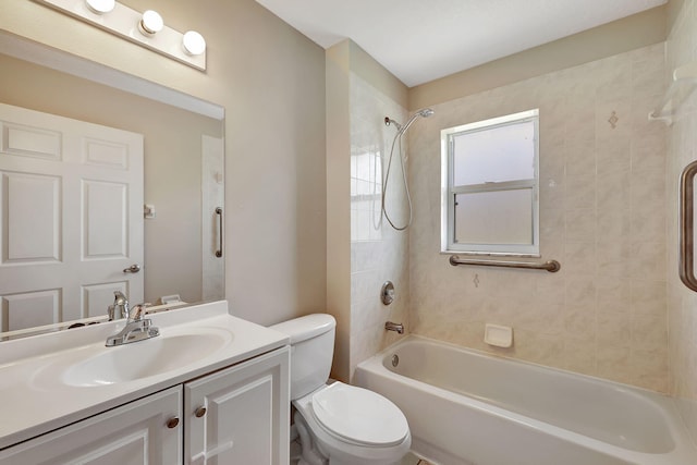 full bathroom featuring tiled shower / bath, vanity, and toilet