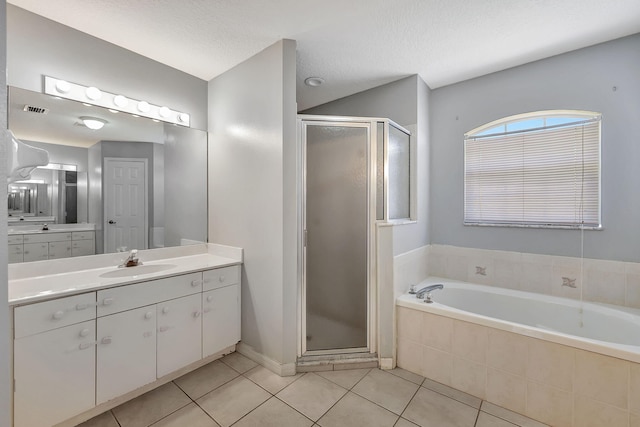 bathroom featuring vanity, separate shower and tub, tile patterned floors, and a textured ceiling