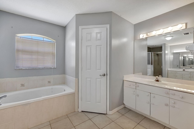 bathroom with vanity, shower with separate bathtub, tile patterned flooring, and a textured ceiling