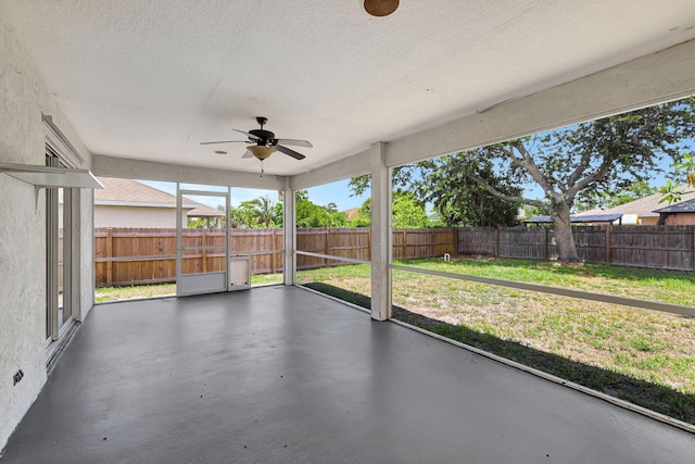 unfurnished sunroom featuring ceiling fan