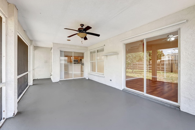 unfurnished sunroom featuring ceiling fan