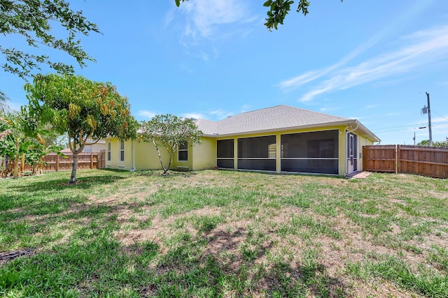 back of property featuring a lawn and a sunroom