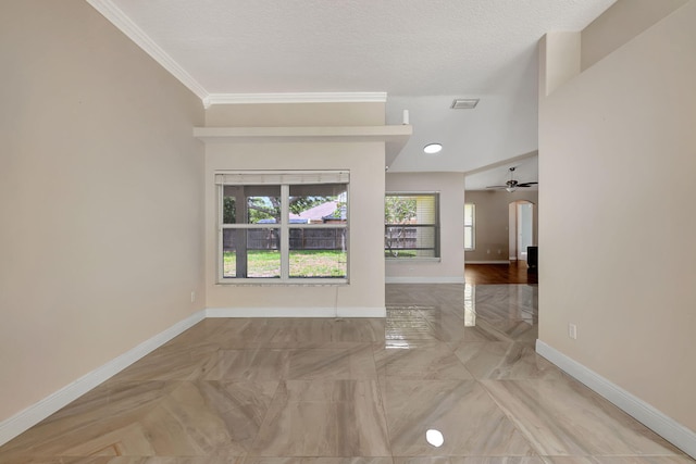 empty room featuring ceiling fan, crown molding, and a textured ceiling