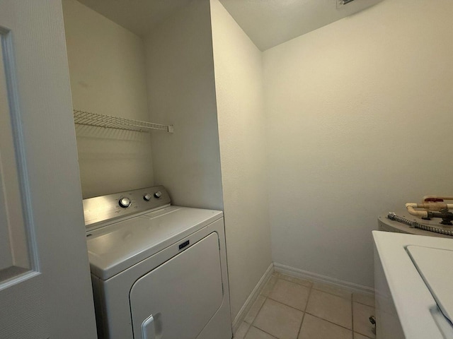 clothes washing area featuring washer and dryer and light tile patterned flooring