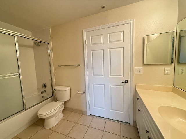 full bathroom featuring vanity, combined bath / shower with glass door, tile patterned floors, and toilet