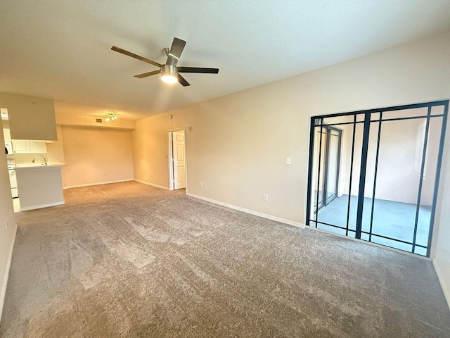 unfurnished living room featuring ceiling fan and carpet flooring