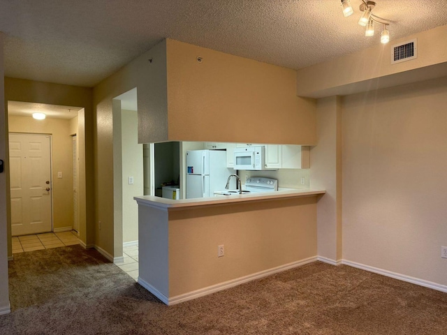 kitchen with white cabinetry, light colored carpet, white appliances, and kitchen peninsula