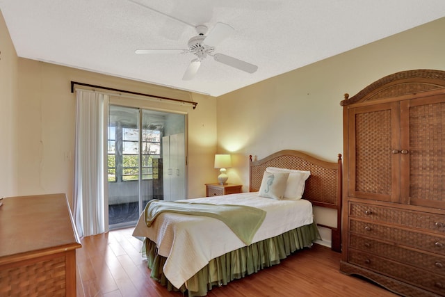 bedroom with a textured ceiling, hardwood / wood-style floors, access to exterior, and ceiling fan