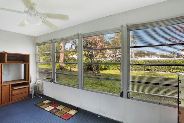 unfurnished sunroom featuring ceiling fan