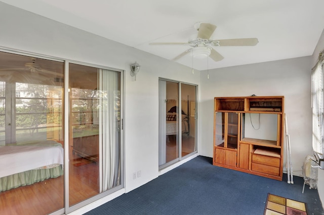 interior space with dark colored carpet and ceiling fan