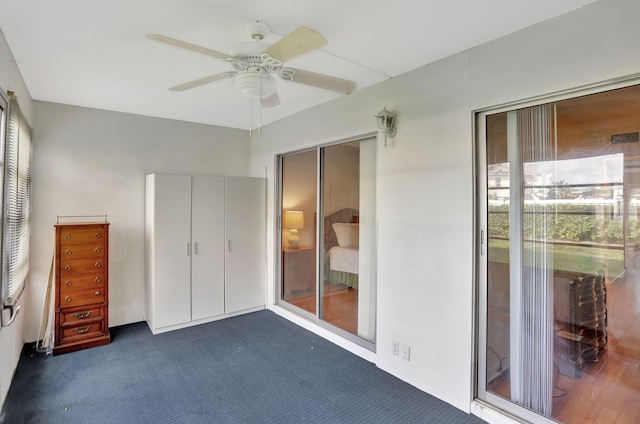 unfurnished bedroom featuring dark colored carpet and ceiling fan