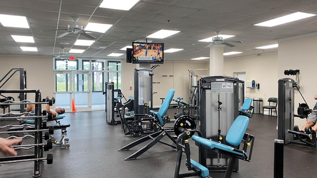 workout area featuring ceiling fan and a drop ceiling