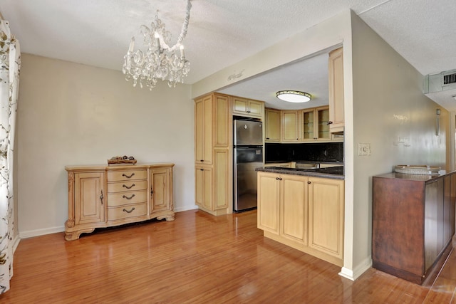 kitchen with stainless steel refrigerator, light hardwood / wood-style flooring, light brown cabinets, and pendant lighting