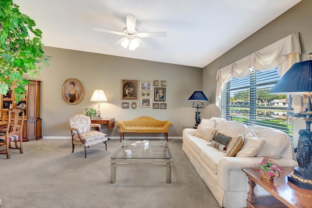 carpeted living room with ceiling fan and vaulted ceiling