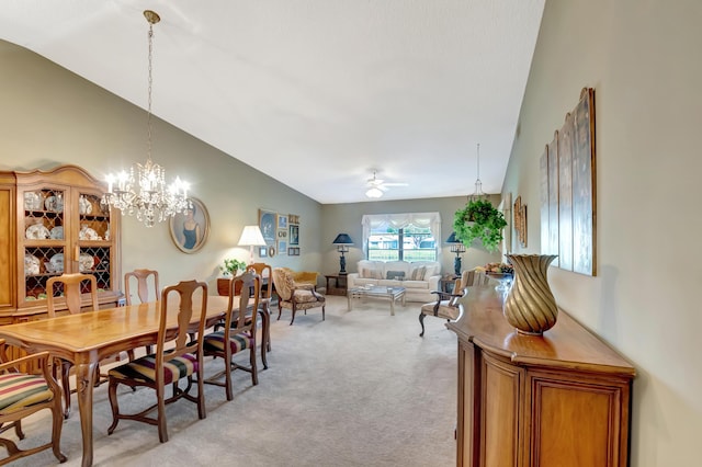 carpeted dining space featuring vaulted ceiling and ceiling fan with notable chandelier