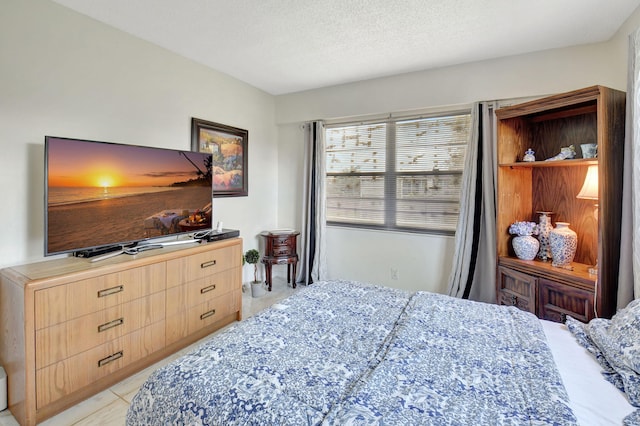 bedroom with light tile patterned floors and a textured ceiling