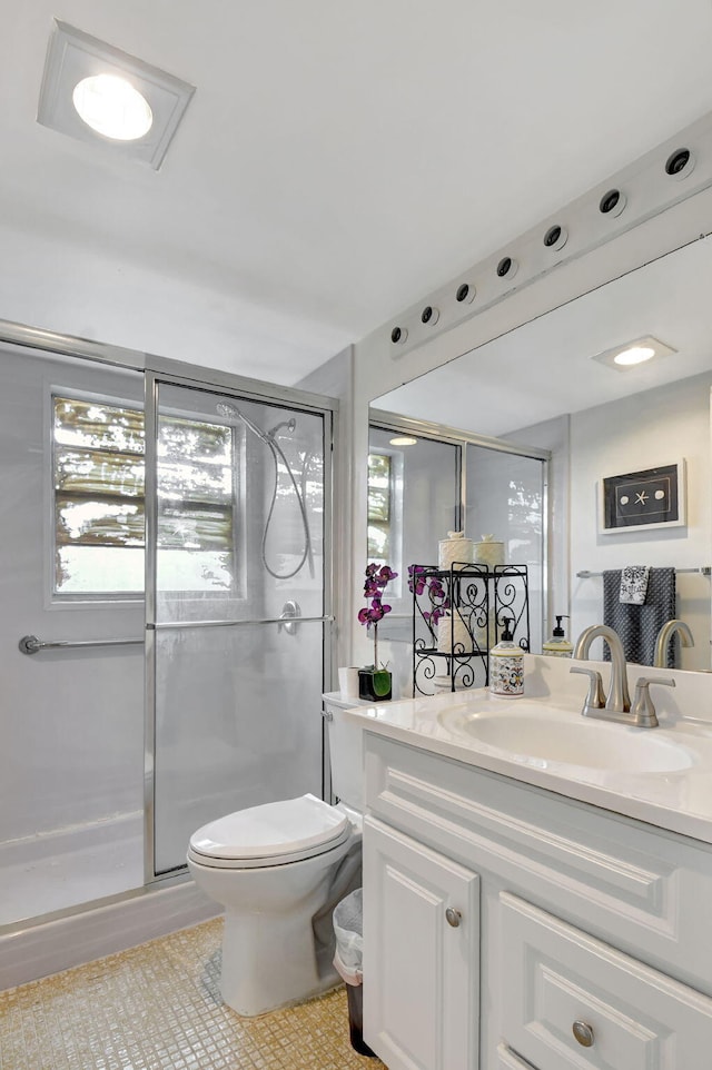 bathroom with a healthy amount of sunlight, toilet, an enclosed shower, and vanity