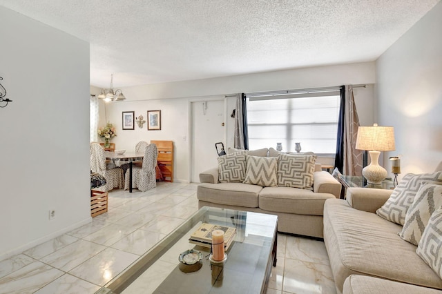 living room featuring a notable chandelier and a textured ceiling