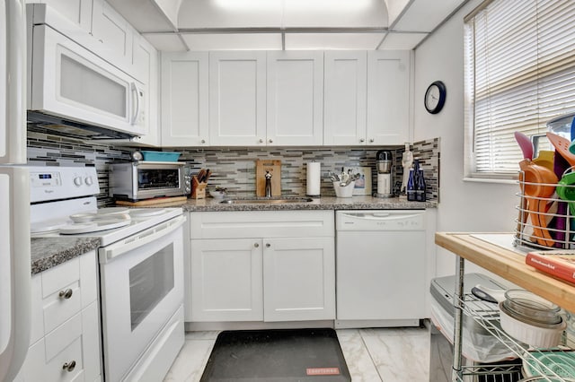 kitchen with sink, white appliances, and white cabinets