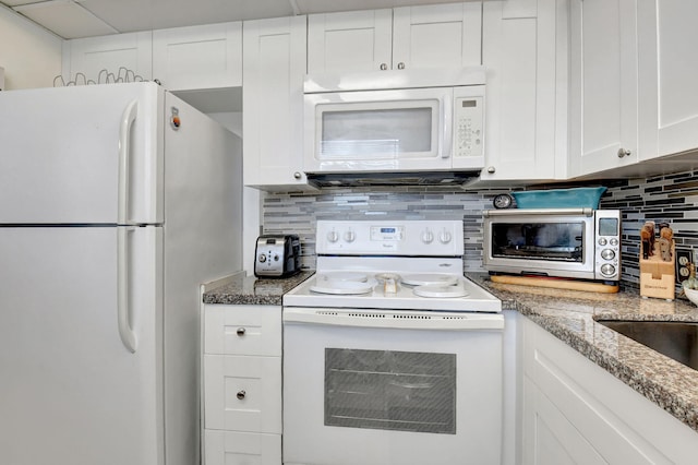 kitchen featuring white appliances, decorative backsplash, and white cabinets