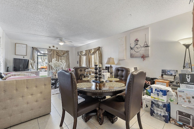 tiled dining room with a textured ceiling and ceiling fan