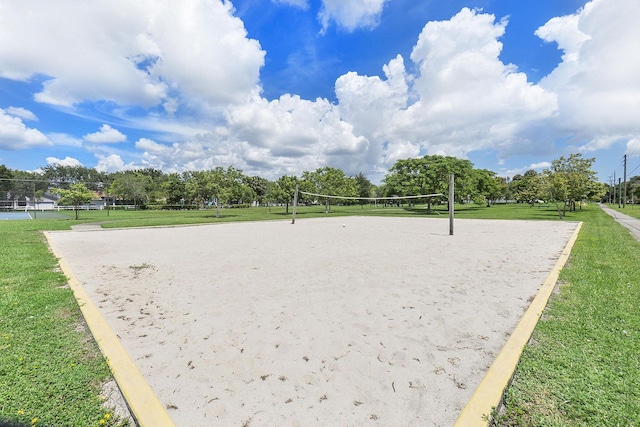 view of property's community featuring a lawn and volleyball court