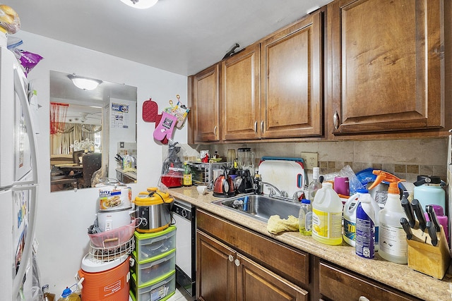 kitchen with tasteful backsplash, sink, dishwasher, and white refrigerator