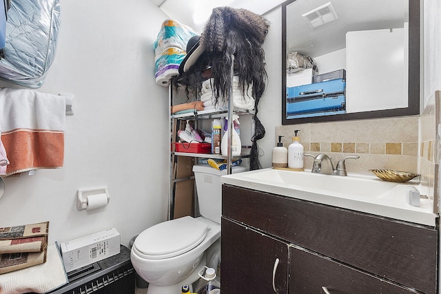 bathroom with vanity, backsplash, and toilet