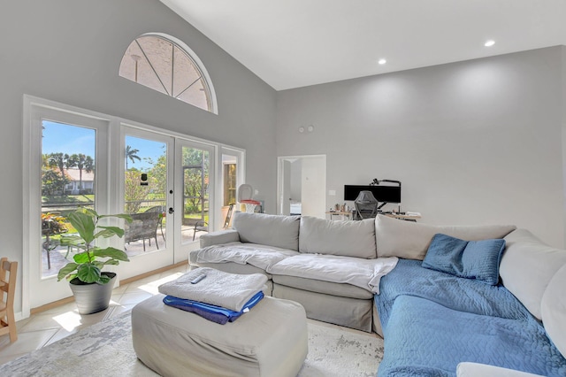 living room featuring a towering ceiling, light tile patterned floors, and french doors