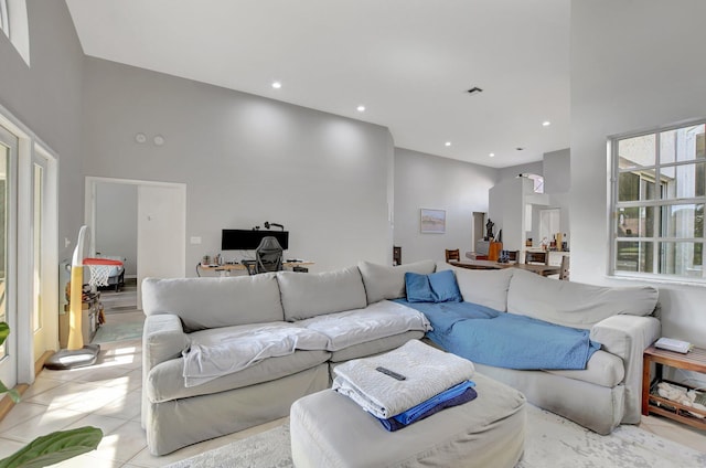 living room with a towering ceiling and light tile patterned floors