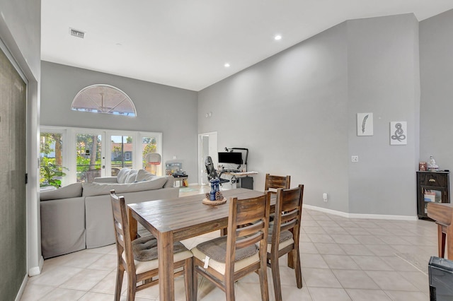 tiled dining area featuring a high ceiling and french doors