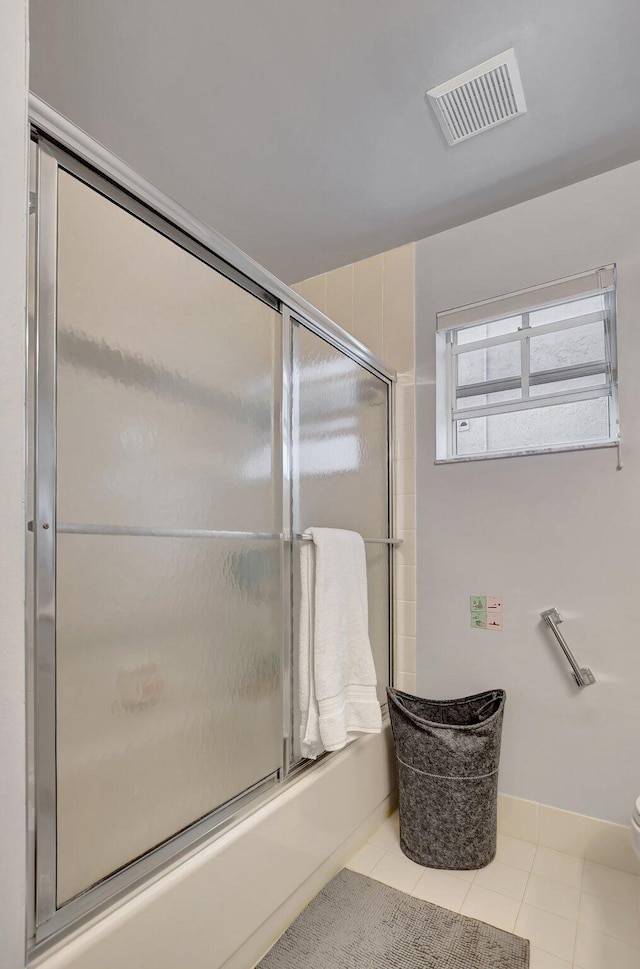 bathroom featuring toilet, tile patterned floors, and shower / bath combination with glass door