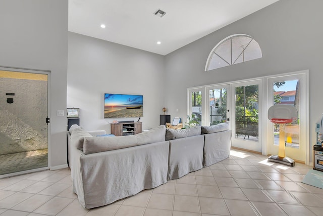 tiled living room with a towering ceiling and french doors